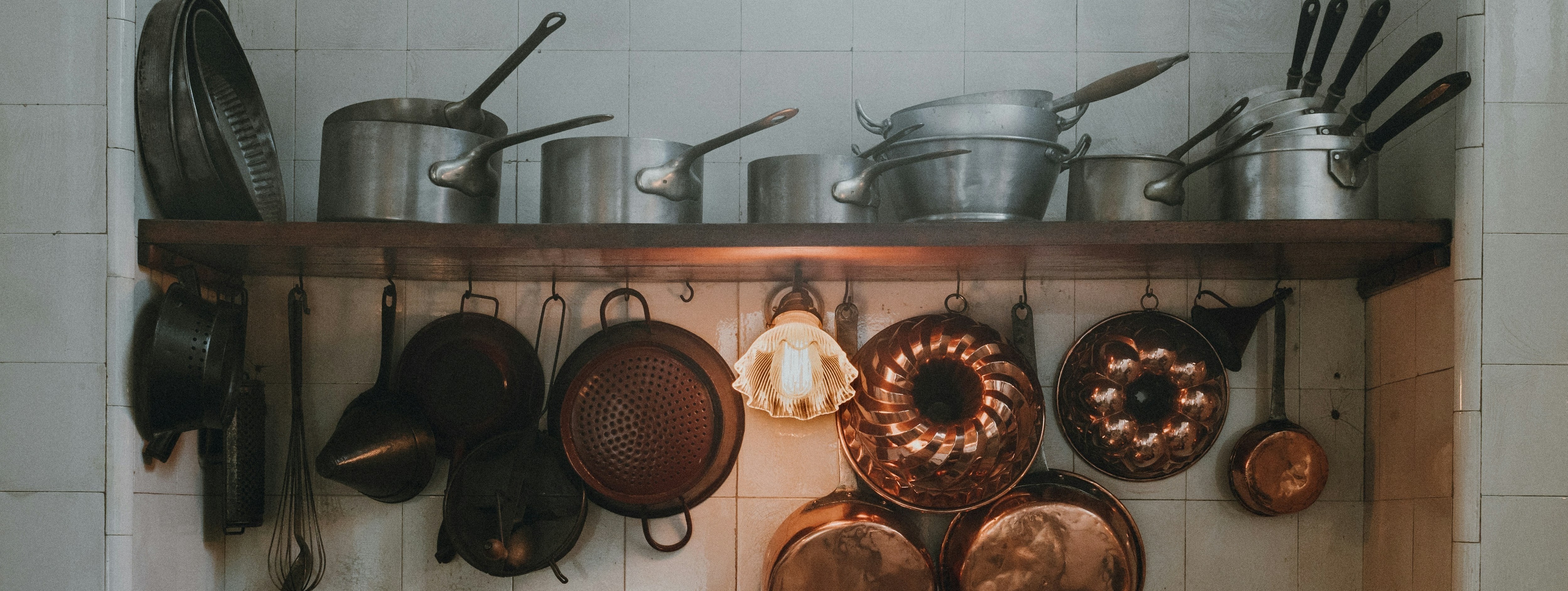 Everyday kitchen items overhead, glass container, wooden spoon, ceramic bowl, product packaging with visible labels