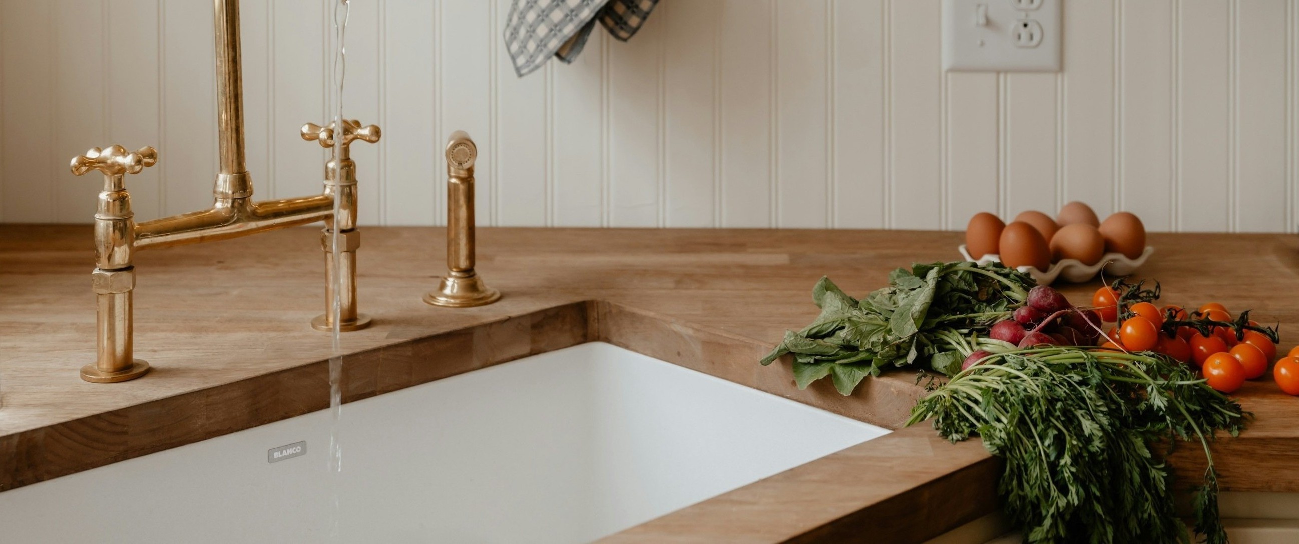 Close-up of a butcher block countertop surface showing end grain, oiled finish, warm natural light