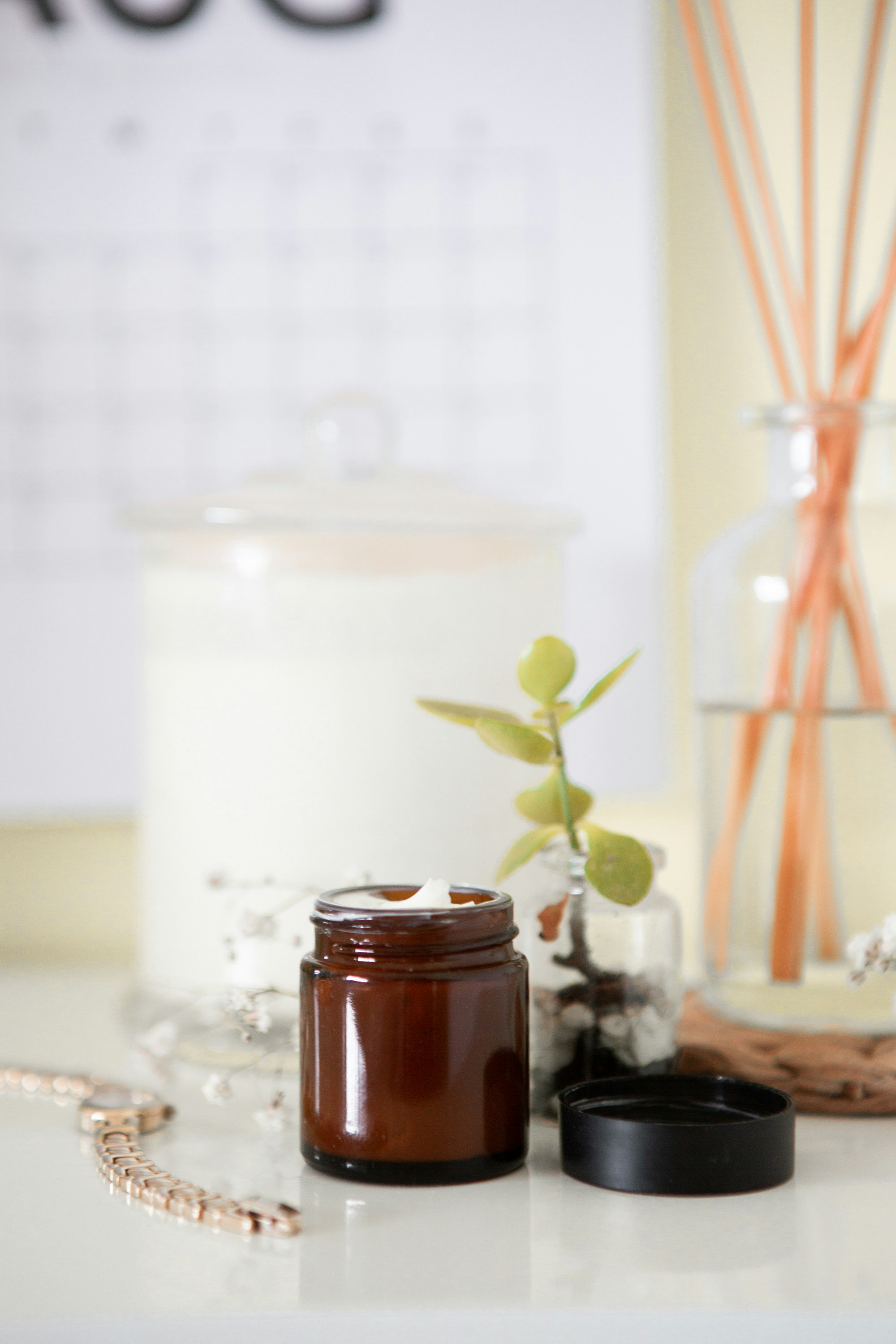 Natural skincare ingredients laid out, aloe, rosehip oil, beeswax, overhead